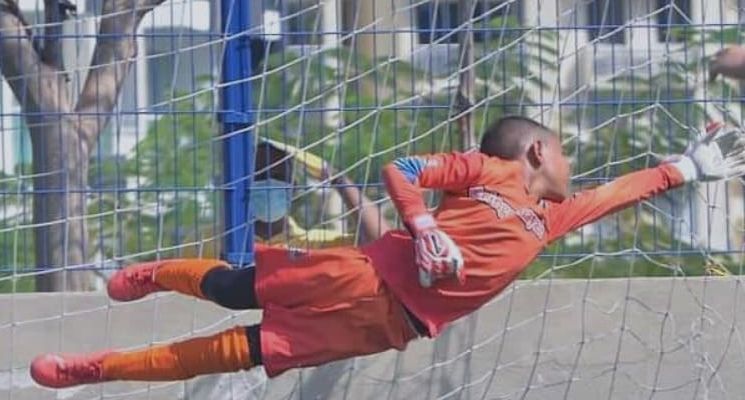 Arquero de la escuela lanzándose a atajar un balón